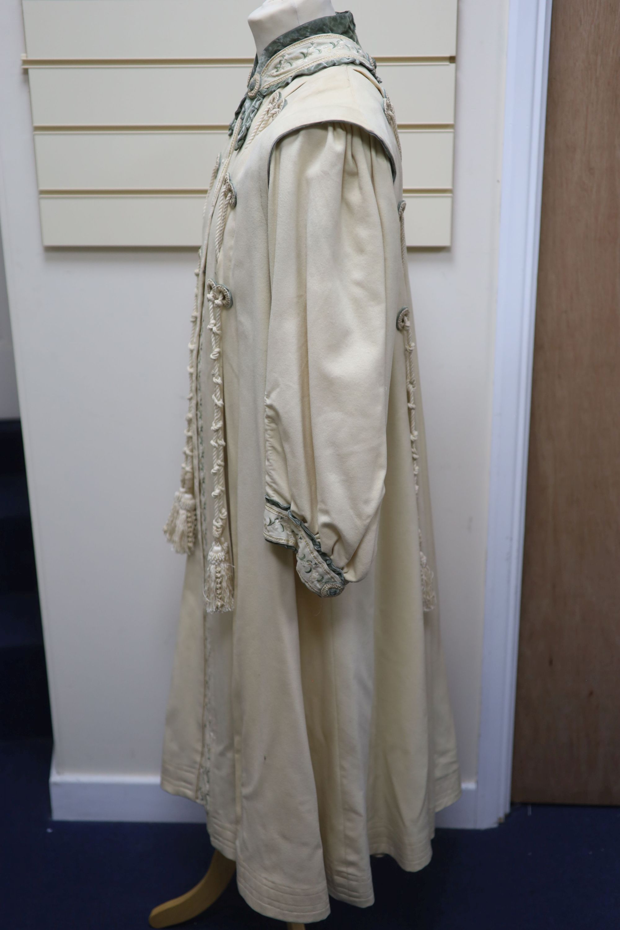 An Edwardian ladies fine cream wool coat with embroidered cuffs front edging and collar and ornate corded tasselling,